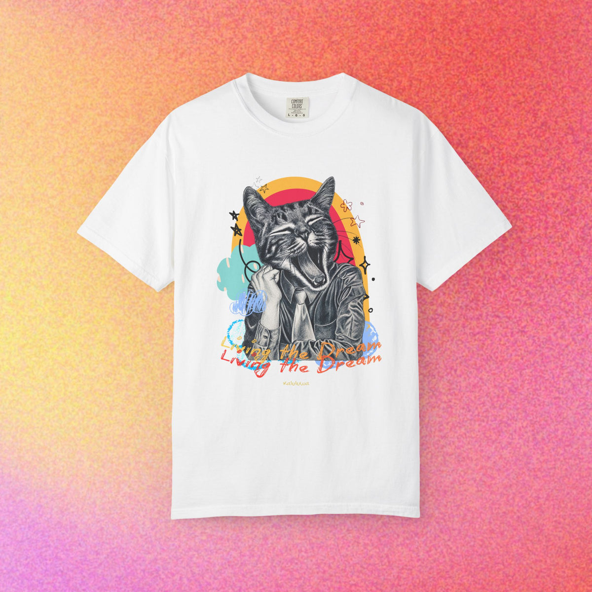 Garment-dyed T-shirt with a tired cat surreal illustration and small text 'Living the Dream' on the front.
